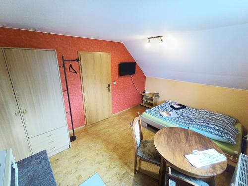 a small room with a bed and a table at Kleines Idyll in Bieberstein