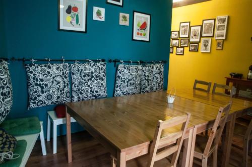 a dining room with a wooden table and chairs at Antique Hostel in Bucharest
