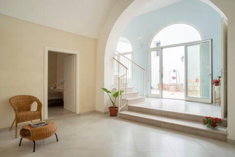 a large white room with a chair and a large window at Casa Vacanze LuLiVi in Giuggianello