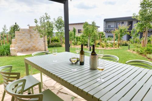 a wooden table with wine bottles and glasses on it at Apartments Vineyard19 in Retz
