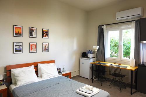 une chambre avec un lit, un bureau et une fenêtre dans l'établissement Under the Palms, à Nicosie