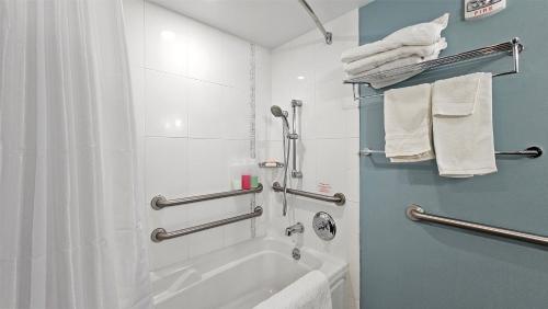 ein Bad mit einer Badewanne und einer Dusche mit Handtüchern in der Unterkunft Ala Moana Hotel _ Ocean view with balcony in Honolulu