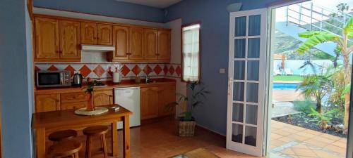 uma cozinha com armários de madeira, uma mesa e uma janela em Espuma de Sal em Mazo