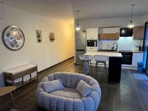 een woonkamer met een bank en een keuken bij Écrin proche des calanques T2 Côte bleue in Ensuès-la-Redonne
