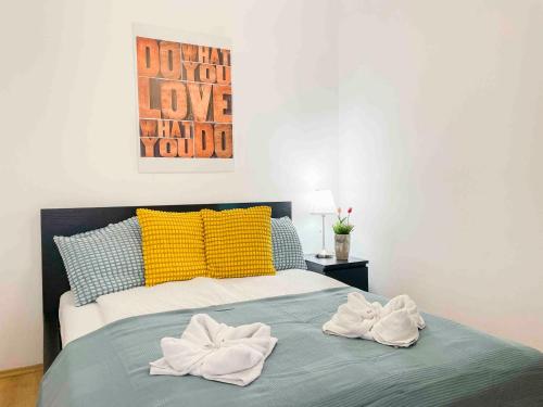 1 dormitorio con 1 cama con almohadas amarillas y azules en Opera Residence en Budapest