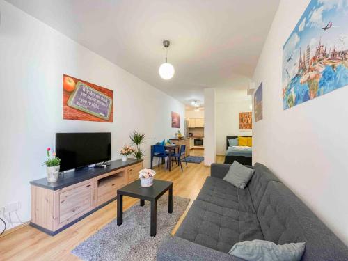 ein Wohnzimmer mit einem Sofa und einem Flachbild-TV in der Unterkunft Opera Residence in Budapest