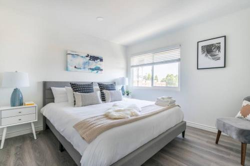 a white bedroom with a large bed and a window at Modern 2BR Condo with King Bed & Balcony near LA in Alhambra