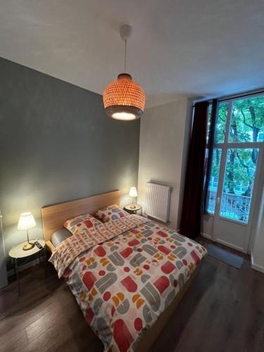 a bedroom with a bed and two lamps and a window at Le Grand HELDER in Vichy