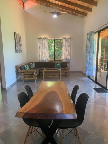 a living room with a wooden table and chairs at Casa Tres Tucanes in Barú