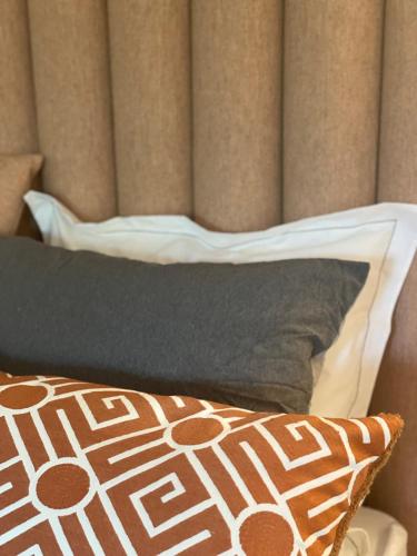 a bed with black and white pillows and a headboard at De Hamrokerij in Kortrijk