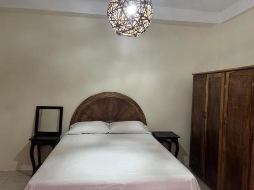 Un dormitorio con una cama y una lámpara de araña. en Casita Luz, en Juayúa