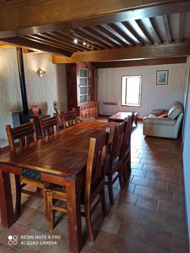 une salle à manger avec une grande table et des chaises en bois dans l'établissement MAISON DE CAMPAGNE, à Vaux-en-Pré