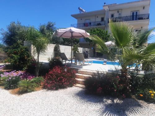 a house with an umbrella and a swimming pool at Amare suite in Perivólia