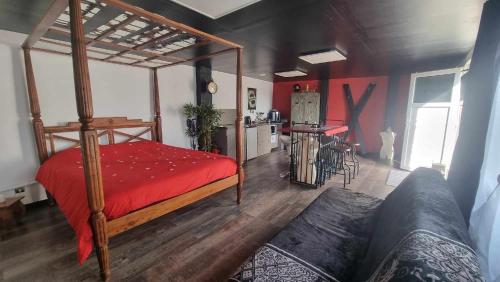 Schlafzimmer mit einem Bett mit einer roten Bettdecke in der Unterkunft Le Glamour Loft in Graincourt-lès-Havrincourt
