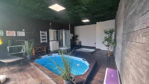 une grande pièce avec un jacuzzi avec des plantes à l'intérieur dans l'établissement Le Glamour Loft, à Graincourt-lès-Havrincourt