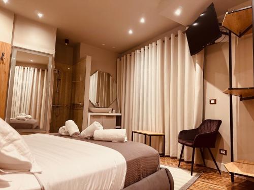 a bedroom with a large bed and a chair at Maxi Wellness Suite in Vlorë