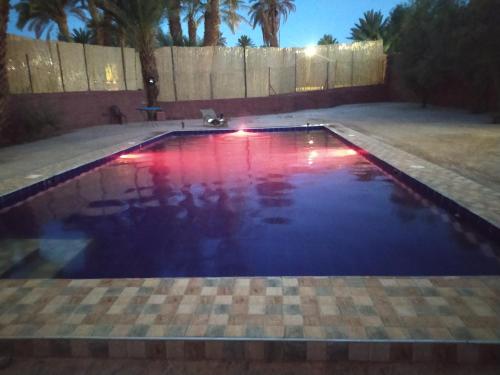 a pool with red and blue water in a backyard at Bivouac Lot Of Stars in Ouarzazate
