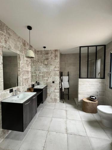 une salle de bain avec une baignoire, un lavabo et des toilettes dans l'établissement Maison de charme avec piscine, à Aigrefeuille-dʼAunis