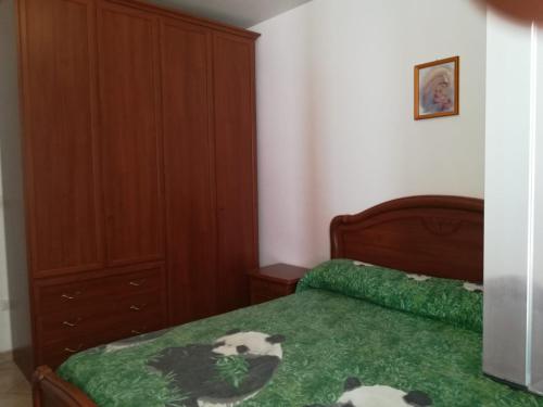 una camera da letto con un letto con un piumone verde di House Pedone a Otranto