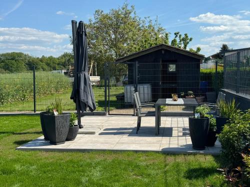 a patio with a table and an umbrella and a shed at Auszeit Birkenhof in Trimbs