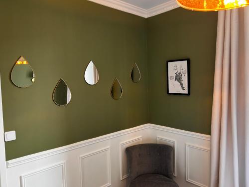 a green room with a chair and mirrors on the wall at Appartement Richard Merrill, en plein centre, 4 pers in Sainte-Mère-Église