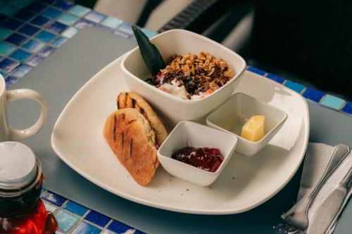 a plate with a bowl of food and aasteryasteryasteryasteryasteryasteryastery at Saigon Bay Bed & Breakfast in Bocas del Toro