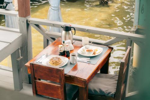 a table with two plates of food on a boat at Saigon Bay Bed & Breakfast in Bocas del Toro