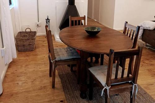 a wooden table with chairs and a bowl on top at Entire cottage in Stormsriver in Stormsrivier