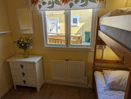 a room with a window and a bed and a table at Vårhaga Vandrarhem in Sjuntorp