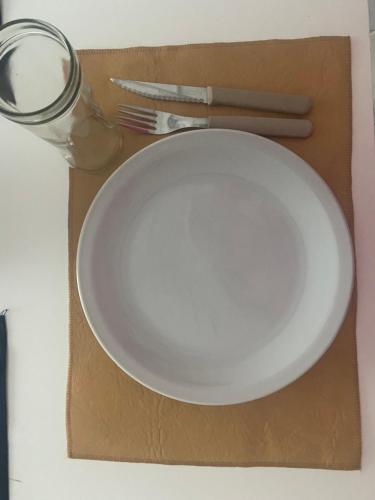 a white plate and a fork and knife on a table at Depto Latorre in General Pico