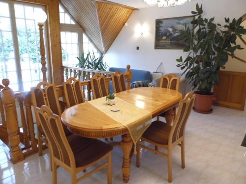 a dining room with a wooden table and chairs at Millennium Villa in Keszthely