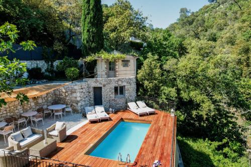 une maison avec une piscine sur une terrasse en bois dans l'établissement Mas des Arts & Spa, à La Colle-sur-Loup