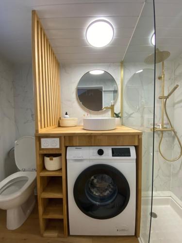- un lave-linge dans la salle de bains pourvue d'un miroir dans l'établissement Margottine, confortable cocon au calme, à Saint-Brévin-les-Pins
