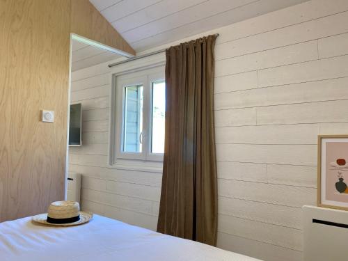 - une chambre avec une fenêtre et un lit avec un chapeau dans l'établissement Margottine, confortable cocon au calme, à Saint-Brévin-les-Pins