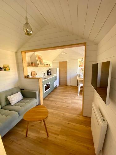 un salon avec un canapé et une cuisine dans l'établissement Margottine, confortable cocon au calme, à Saint-Brévin-les-Pins