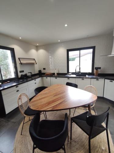 une cuisine avec une table et des chaises en bois dans l'établissement Maison de charme avec piscine, à Aigrefeuille-dʼAunis