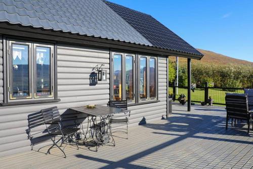 a patio with a table and chairs on a house at Charming Cabin close to Akureyri in Halllandsnes