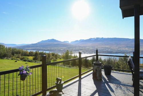 a balcony with a fence and mountains in the background at Charming Cabin close to Akureyri in Halllandsnes