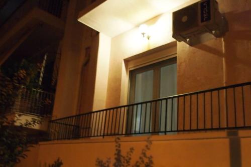 a balcony of a building with a window at night at Big Oasis near the center of Athens in Athens