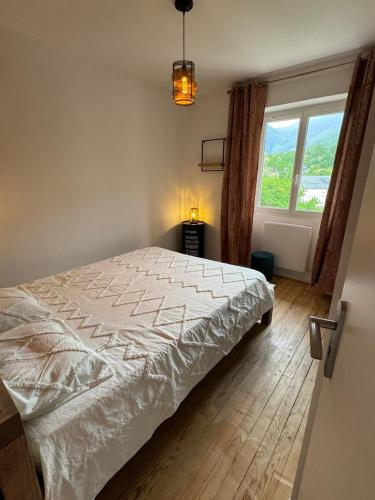 une chambre avec un lit blanc avec une fenêtre dans l'établissement Le Grillon, à Ax-les-Thermes