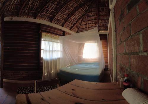 a room with a bed in a building with a window at hostal pakal in Mazunte