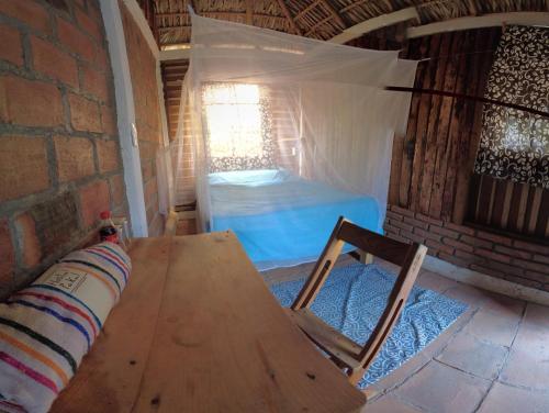 una mesa y una silla en una habitación con cama en hostal pakal, en Mazunte