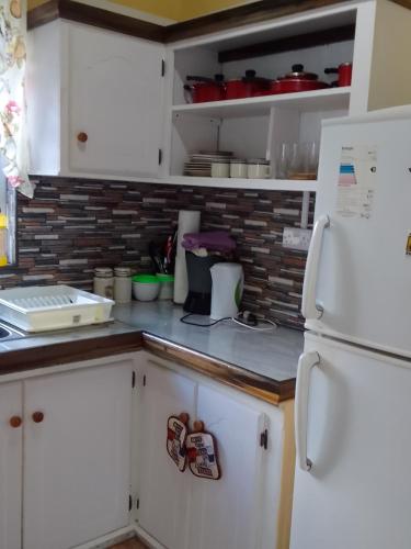 a kitchen with white cabinets and a white refrigerator at River Splash Apartment & Cottage in Marigot