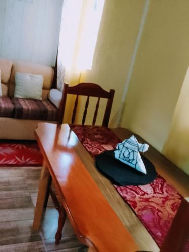 Cette petite chambre comprend une table et un banc avec un chapeau. dans l'établissement River Splash Apartment & Cottage, à Marigot