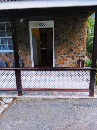 a stone house with a window and a door at River Splash Apartment & Cottage in Marigot