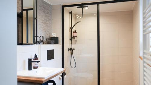 a bathroom with a shower and a sink at Modernes Ferienhaus im Eidertal in Delve