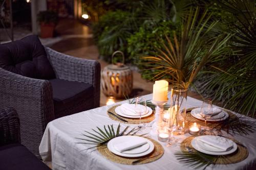 a table with plates and candles on top of it at GREEN HILL Aparts with POOL & SCENIC VIEW in Gornji Orahovac