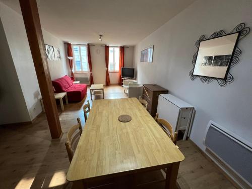 une chambre avec une table en bois et un salon dans l'établissement Appartement atypique d'AX, à Ax-les-Thermes
