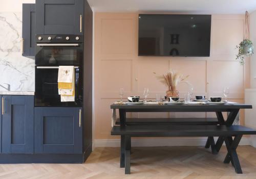 a kitchen with a black table with wine glasses on it at Bee Stays - Long Lane in Warrington