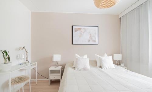 - une chambre blanche avec un grand lit blanc et 2 oreillers dans l'établissement 3 h + keittiö ja parveke, juuri remontoitu!, à Lahti
